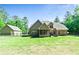 Expansive fenced backyard with lush lawn, patio, screened in porch, and detached garage at 105 Chantilly Ln, Fayetteville, GA 30215