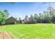 A large grassy backyard with a detached garage and a home with a screened-in porch at 105 Chantilly Ln, Fayetteville, GA 30215