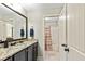 Bathroom with granite countertops, dark cabinetry, and tiled shower at 105 Chantilly Ln, Fayetteville, GA 30215