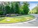 Entrance to Chantilly with a stone sign surrounded by landscaped shrubs, trees, and manicured lawn at 105 Chantilly Ln, Fayetteville, GA 30215