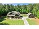 Eye-level exterior showcasing a two-story home with a detached garage, landscaped yard, and verdant trees in background at 105 Chantilly Ln, Fayetteville, GA 30215