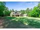 Spacious home with lush green lawn, mature trees and landscaping, plus a detached garage at 105 Chantilly Ln, Fayetteville, GA 30215