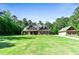 Beautiful two-story brick home with a large front lawn and mature trees at 105 Chantilly Ln, Fayetteville, GA 30215