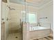 Spacious bathroom featuring a glass-enclosed shower and separate soaking tub with tile surround at 105 Chantilly Ln, Fayetteville, GA 30215