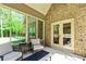 Screened in porch featuring brick walls and neutral furniture with views of a grassy lawn at 105 Chantilly Ln, Fayetteville, GA 30215