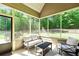 A screened porch with a seating area and an outdoor view of the backyard at 105 Chantilly Ln, Fayetteville, GA 30215