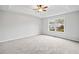 Spacious bedroom with a ceiling fan, carpeted floors, and a backyard view from the window at 162 Brookhaven Way, Rockmart, GA 30153