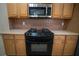 Close up of oven and cooktop with microwave and cabinets, creating a culinary space at 2548 Gadsen Walk, Duluth, GA 30097