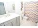 Well-lit bathroom with a modern vanity and sink, decorative mirror and zig-zag pattern shower curtain at 2589 Cajun Dr, Marietta, GA 30066