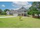 Lovely two-story house with green lawn, features a brick facade, garage, and mature landscaping at 2589 Cajun Dr, Marietta, GA 30066