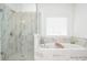 Beautiful bathroom features a seamless glass shower and soaking tub with marble tile surround at 2589 Cajun Dr, Marietta, GA 30066