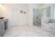 Large bathroom featuring marble tile, frameless shower, soaking tub, and dual sink vanity at 2589 Cajun Dr, Marietta, GA 30066