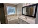 Bright bathroom with a soaking tub, white vanity, and a framed mirror at 510 Ward Rd, Ellenwood, GA 30294
