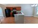 An open kitchen featuring wood cabinets, black appliances, a breakfast bar, and hardwood floors at 510 Ward Rd, Ellenwood, GA 30294