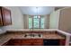 A kitchen featuring a double sink, wood cabinets and a view through bay windows at 510 Ward Rd, Ellenwood, GA 30294