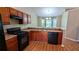 Cozy kitchen area with wood cabinets, black appliances, and an attached dining area with bay windows at 510 Ward Rd, Ellenwood, GA 30294