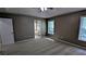 Spacious carpeted main bedroom with a ceiling fan, two windows, and an en suite bathroom at 510 Ward Rd, Ellenwood, GA 30294
