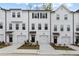 Charming townhomes boast a fresh, modern aesthetic with white siding, black accents, and single car garages at 3170 Washburn Sw St, Atlanta, GA 30354