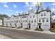 Attractive row of townhomes with white facades, dark roofs, garages, and well-maintained landscaping at 3170 Washburn Sw St, Atlanta, GA 30354