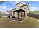 A spacious backyard with a graveled area, a covered patio, a wooden fence, and manicured greenery at 550 Eldridge Dr, Suwanee, GA 30024