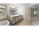 Bathroom features a large mirror, double vanity, tub and a window at 550 Eldridge Dr, Suwanee, GA 30024
