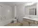 Bathroom featuring a shower/tub combo, a vanity, neutral tile, and a toilet in a naturally lit space at 550 Eldridge Dr, Suwanee, GA 30024