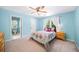 Bright bedroom with colorful bedding, ceiling fan, and a window letting in natural light, with ensuite bath access at 3465 Summit Trl, Cumming, GA 30041