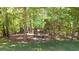 Cozy firepit area nestled amongst mature trees provides a tranquil retreat for gatherings at 3465 Summit Trl, Cumming, GA 30041