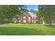 Charming two-story brick home with a large, well-manicured front lawn and mature trees at 3465 Summit Trl, Cumming, GA 30041