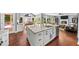 Open-concept kitchen with a large island, hardwood floors, and a view into the living room with a fireplace at 3465 Summit Trl, Cumming, GA 30041