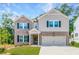 Two story home featuring a brick facade, gray siding, dark shutters, and a well-manicured lawn at 3981 Adler Cir, Buford, GA 30519
