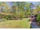 Lush backyard with mature trees and landscaping, featuring a deck with outdoor seating at 4048 Suzanne Ln, Duluth, GA 30096