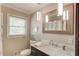 Bathroom featuring a vanity with a marble countertop and a decorative mirror and light fixture at 4048 Suzanne Ln, Duluth, GA 30096
