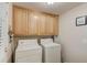 Bright laundry room with washer, dryer and storage cabinets at 4048 Suzanne Ln, Duluth, GA 30096