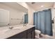 Modern bathroom featuring a double sink vanity, large mirror, and a shower with a blue curtain at 4929 Dufour Dr, Lilburn, GA 30047