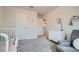 Bedroom with cozy chair, crib, dresser, neutral colors, and carpet at 4929 Dufour Dr, Lilburn, GA 30047