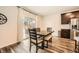 Cozy dining area with wood flooring, wooden table, view to the backyard, stainless steel refrigerator and dark cabinets at 4929 Dufour Dr, Lilburn, GA 30047
