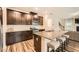 Open kitchen features an island with barstool seating, stainless appliances and dark wood cabinets at 4929 Dufour Dr, Lilburn, GA 30047