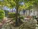 A beautifully landscaped yard with a stone patio, lush plantings, and a cozy deck at 7 Nesbit Pl, Alpharetta, GA 30022