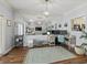 Spacious living room with lots of natural light, light wood floors, and an accent wall mirror at 7 Nesbit Pl, Alpharetta, GA 30022