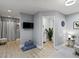 Bright living area featuring luxury vinyl floors, a mounted TV, and an open powder room at 7 Nesbit Pl, Alpharetta, GA 30022