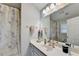 This bathroom features a large mirror, vanity, shower with tub and floral shower curtain at 801 Old Peachtree Nw Rd # 56, Lawrenceville, GA 30043