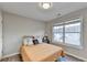 Bright bedroom features wood-look floors, a large window, and neutral paint at 801 Old Peachtree Nw Rd # 56, Lawrenceville, GA 30043
