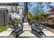 Outdoor seating with sleek chairs and a central fire pit, surrounded by green landscaping at 1076 Manigault Se St, Atlanta, GA 30316