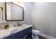 Chic powder room featuring a marble countertop, navy blue vanity, and brushed gold fixtures at 1076 Manigault Se St, Atlanta, GA 30316