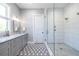 Bright bathroom featuring a double vanity with a marble countertop and a glass enclosed shower with white tiling at 1076 Manigault Se St, Atlanta, GA 30316