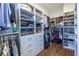 Large walk-in closet with custom shelving, hanging rods, shoe shelves and a hardwood floor at 1076 Manigault Se St, Atlanta, GA 30316