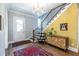 Bright foyer with patterned accent wall, staircase, and stylish furnishings at 1076 Manigault Se St, Atlanta, GA 30316