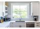 Bright kitchen with white cabinets, stainless steel appliances, and a window overlooking the backyard at 1076 Manigault Se St, Atlanta, GA 30316