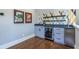 Close up of wet bar with beverage cooler, gray cabinetry, and hardwood floor at 1076 Manigault Se St, Atlanta, GA 30316